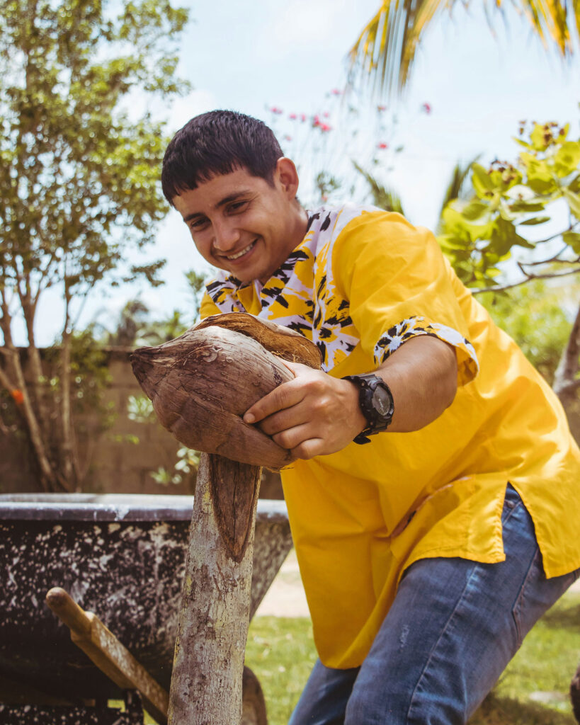 husking coconut to make hudut Garifuna recipe in Belize